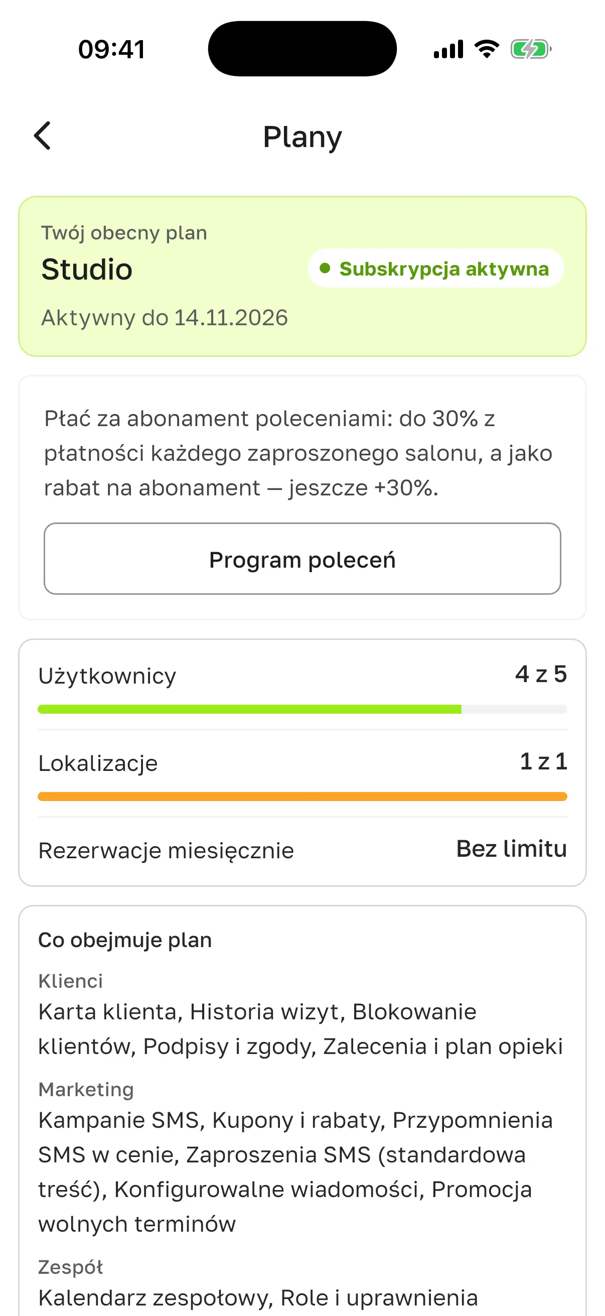 Ekran „Plany” na iPhonie, salon już po pierwszej płatności: „Twój obecny plan” Studio, „Subskrypcja aktywna”, „Aktywny do 14.11.2026”, karta „Płać za abonament poleceniami…” z przyciskiem „Program poleceń”, „Użytkownicy” 4 z 5, „Lokalizacje” 1 z 1, „Rezerwacje miesięcznie” bez limitu, sekcja „Co obejmuje plan”